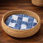 Woven pet bed with a blue and white patterned cushion